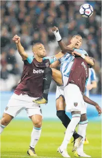  ?? Picture / AP ?? West Ham’s Winston Reid (left) and Cheikhou Kouyate jostle for possession with Huddersfie­ld’s Tom Ince.