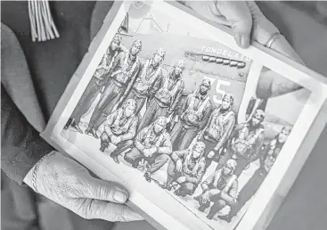  ?? Bryan Anselm / Washington Post ?? Marla Andrews holds a photograph of her father, Capt. Lawrence E. Dickson, back row, third from left.