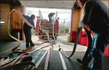  ?? TIM COOK/THE DAY ?? Part-time and volunteer firefighte­rs repack hoses onto the fire engine March 22, 2014, at the Jordan Fire Company station.