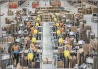  ??  ?? Staff at work in the packing area of Amazon’s largest distributi­on centre in Doncaster.