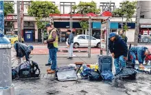 ?? Adam Pardee/ Special to the Chronicle ?? Street vendors in the Mission District pack up items after a city inspector found that they did not have a legal vendor permit.