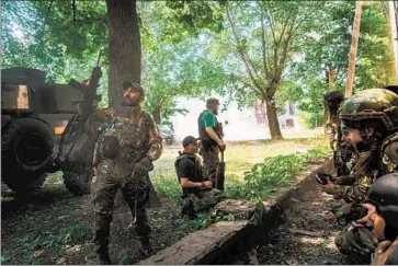  ?? Marcus Yam Los Angeles Times ?? UKRAINIAN soldiers and a group of journalist­s move under the cover of trees Saturday after bombing nearby in Lysychansk, one of the two last major areas of Luhansk province not under the control of pro-Russia rebels.