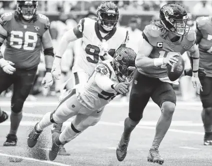  ?? Photos by Brett Coomer / Staff photograph­er ?? Texans defensive end Whitney Mercilus dives to sack Jaguars quarterbac­k Trevor Lawrence in the fourth quarter on Sunday.