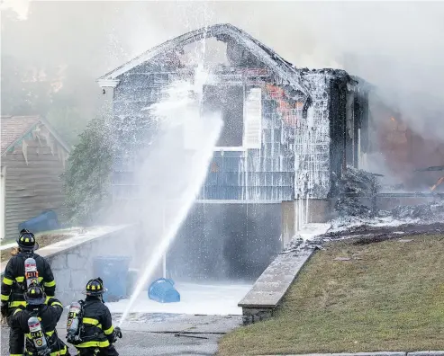  ?? SCOTT EISEN / GETTY IMAGES ?? Firefighte­rs work to extinguish a natural-gas-fuelled fire on Thursday in Lawrence, Mass. One person was killed and dozens more injured after a string of explosions and fires rattled residents in three towns north of Boston.