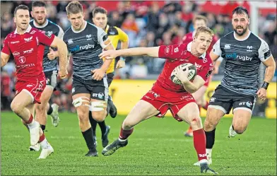  ??  ?? Scarlets’ Johnny McNicholl puts pressure on the Ospreys defence