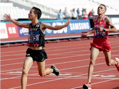  ?? AP ?? Japan’s Hiroto Inoue (left) crosses the finish line ahead of Bahrain’s Elhassan Elabbassi to win the men’s marathon. —