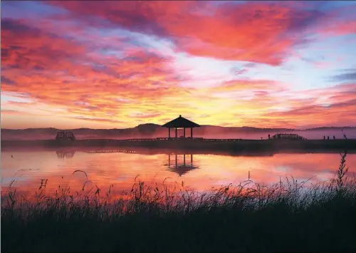  ?? ZOU HONG / CHINA DAILY ?? The sun rises over Qixing Lake in the Saihanba National Forest Park on the border of Hebei province and the Inner Mongolia autonomous region.