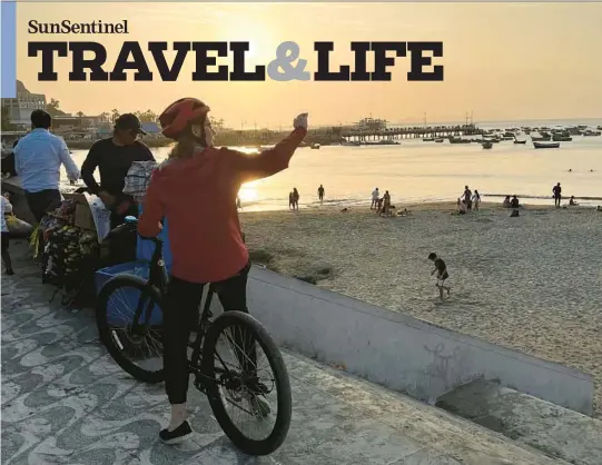  ?? COLLEEN THOMAS/TNS PHOTOS ?? Cyclists on a bike tour stop to gaze at the view along the oceanfront in Lima, Peru.