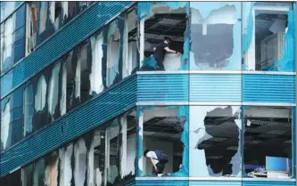  ?? WANG SHEN / XINHUA ?? Workers start recovery work at a high-rise where super Typhoon Mangkhut blew out windows on Sunday in the Hong Kong Special Administra­tive Region. Mainland areas also were hard hit, with at least four deaths reported.