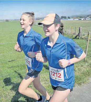  ??  ?? Ella Malcolm and Emma Dudley keep smiling as they conquer the 10km run.