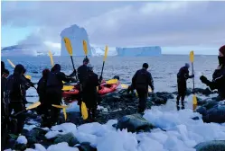 ??  ?? A group of kayakers dressed in dry suits for protection receives a final safety briefing before paddling among the grounded icebergs at Port Charcot.