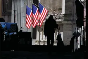  ?? The Associated Press ?? In this Oct. 14, 2020, file photo, pedestrian­s pass the New York Stock Exchange in New York. Stocks are getting back to rallying on Wall Street after Congress, in a late-night session, certified Democrat Joe Biden’s Electoral College victory. The S&P 500 rose 0.8% in the early going Thursday, on its way to another record high.