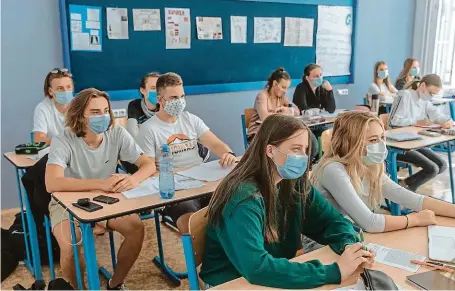  ?? FOTO MAFRA – PETR TOPIČ ?? S ústenkou ve třídě. Studenti z pražského Gymnázia na Zatlance si v pátek poprvé vyzkoušeli výuku v rouškách. Ne každý ji snáší dobře.