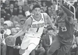  ??  ?? Suns guard Devin Booker drives on the Mavericks’ Wesley Matthews on Wednesday at Talking Stick Resort Arena.