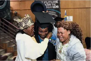  ??  ?? A fresh graduate in tears as she is hugged by an older relative, while her mother (right) is equally emotional, unable to hold back her tears of joy.