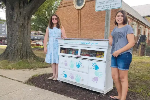  ??  ?? Amanda Santana (left) and Anna Rissi stand with their Little Free Pantry project in Alexandria. — Pictures from Reuters