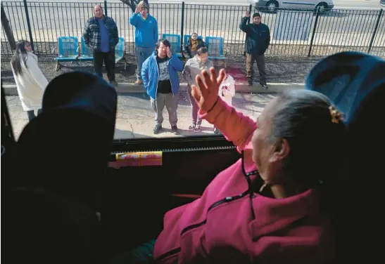  ?? ANTONIO PEREZ/CHICAGO TRIBUNE PHOTOS ?? Claudia Perez waves to her family while inside a bus, Feb. 19 as she leaves Chicago to return to her native Mexico.
