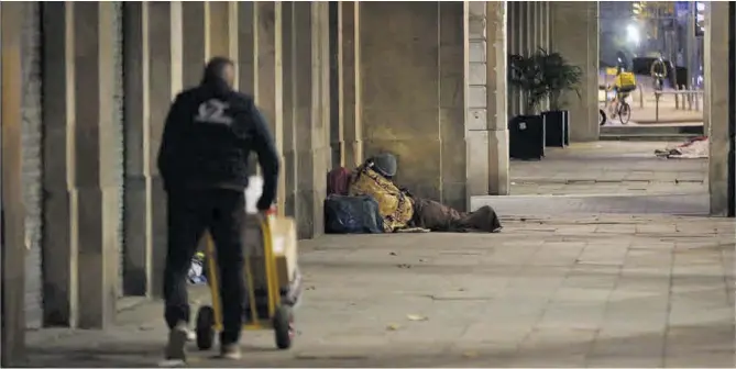  ?? Elisenda Pons ?? Un hombre duerme en los soportales del paseo de Isabel II, junto al parque de la Ciutadella, en Barcelona.