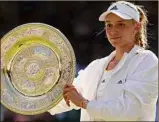  ?? Julian Finney / Getty Images / TNS ?? Elena Rybakina of Kazakhstan celebrates with the trophy after rallying to victory against Ons Jabeur of Tunisia.