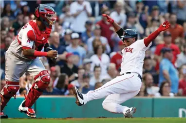 ?? AP PHOTO BY CHARLES KRUPA ?? Boston Red Sox's Rafael Devers scores on a double by Jackie Bradley Jr. during the second inning of a baseball game against the Los Angeles Angels at Fenway Park in Boston, Tuesday, June 26, 2018. At left is Angels catcher Martin Maldonado.