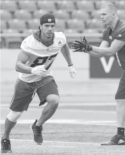  ?? WAYNE CUDDINGTON/POSTMEDIA ?? Receiver Joshua Stangby runs past Trevor Harris during the Redblacks first return to the field after a 24-19 win Wednesday over Montreal. Ottawa plays its third game in 11 days on Monday when the team faces the Toronto Argonauts — and a possible top...