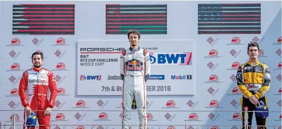  ??  ?? Al Faisal al Zubair (centre) stands on the podium after winning the first race of the second round of the Porsche BWT GT3 Cup Challenge Middle East Series at the Bahrain Internatio­nal Circuit in Sakhir, Bahrain, on Friday