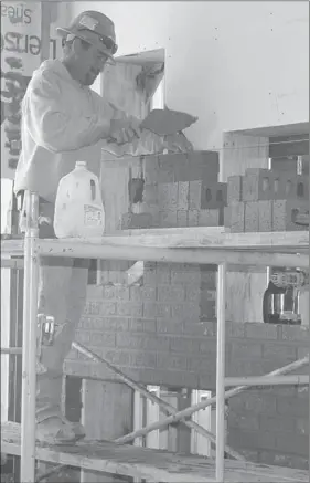  ?? PAT HARRIS ENTERPRISE-LEADER ?? Bobby Walker was laying bricks on an inside wall of the youth section at the new Lincoln Public Library.