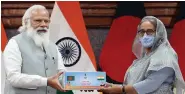  ?? ANI ?? A file photo of Prime Minister Narendra Modi handing over a representa­tional item to Bangladesh PM Sheikh Hasina as a symbol of India’s gift of 1.2 million Covid vaccine doses, in Dhaka on 27 March 2021.