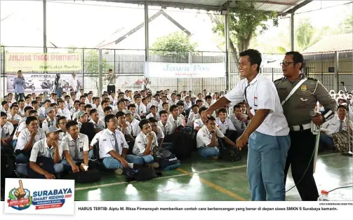  ?? DIKA KAWENGIAN/JAWA POS ?? HARUS TERTIB: Aiptu M. Rikza Firmansyah memberikan contoh cara berbonceng­an yang benar di depan siswa SMKN 5 Surabaya kemarin.