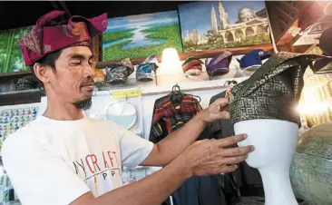  ??  ?? Popular demand: Mohd Iskandar arranging a ‘tanjak’ in his shop at Perkampung­an Kraf, Johor Baru. — THOMAS YONG/THE star