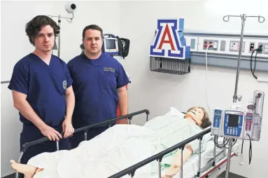  ?? SAM CARAVANA/THE REPUBLIC ?? At the University of Arizona College of Medicine in Phoenix, Drs. Jeff Tully (left) and Christian Dameff stand over a dummy used in simulation­s of cyberattac­ks on medical devices. Dameff says the time to figure out how to prevent such attacks is now,...