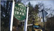  ?? JESSICA HILL — THE ASSOCIATED PRESS FILE ?? A school bus drives past a sign reading Welcome to Sandy Hook in Newtown, Conn., where 26 people were killed by a gunman inside Sandy Hook Elementary School.