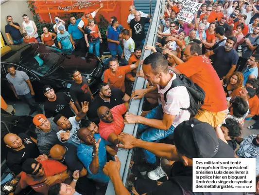  ?? PHOTO AFP ?? Des militants ont tenté d’empêcher l’ex-président brésilien Lula de se livrer à la police hier en bloquant l’entrée du siège du syndicat des métallurgi­stes.