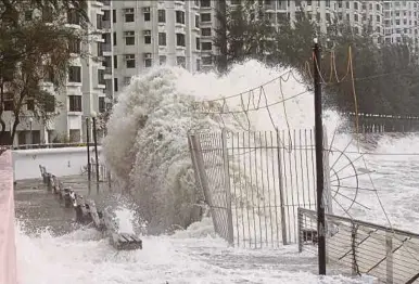  ?? EPA PIC ?? Large waves crashing against a sea wall next to a housing estate when tropical storm Pakhar slammed into Hong Kong yesterday.