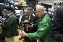  ?? THE ASSOCIATED PRESS ?? Kevin Walsh, right, moves between fellow traders as he works on the floor of the New York Stock Exchange.