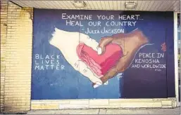  ??  ?? A QUOTE from Julia Jackson, mother of shooting victim Jacob Blake, adorns a mural promoting unity in Kenosha, where many stores remain boarded up.