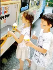  ?? Lynn Atkins/The Weekly Vista ?? Zoey and Andrew Leach add thier own flavors to snow cones at the library last week after they signed up for the Summer Reading Program.