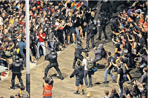  ??  ?? Following the jailing of independen­ce moment leaders, activists in Barcelona hold up signs in Catalan reading ‘everybody to the airport’, top left, where later riot police clashed with protesters, above