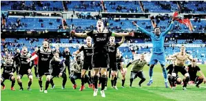 ?? — Gambar AFP ?? PARA pemain Ajax meraikan kejayaan mereka melangkah ke peringkat suku akhir Liga Juara-Juara bersama penyokong selepas tamat perlawanan di Santiago Bernabeu, Madrid Selasa lepas.