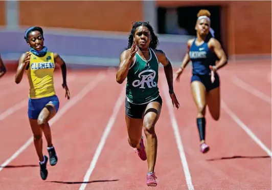  ?? Photos by Ronald Cortes / Contributo­r ?? Reagan senior sprinter Jasmine Montgomery, center, won two individual races and was part of the record-setting 400-meter relay team Saturday at Heroes Stadium.