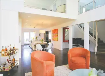  ??  ?? At this 2,911-square-foot Vancouver home at 3655 Trafalgar Street, a glass-sided staircase leads to two upper levels — the first displaying a galleried landing looking down into the living room.