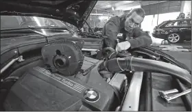  ?? Elaine Thompson/AP ?? Service shop: In this Wednesday, April 25 photo, auto technician Anthony Sterns works to replace the coolant expansion tank on a 2011 BMW at the Fat City German Car service shop in Seattle.