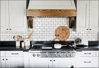  ?? The Washington Post/Travis J Photograph­y ?? This kitchen by Studio McGee features standard subway tile with a darker grout. Subway tile is a go-to because it pairs easily with so many different styles, designer Shea McGee says. “It’s also really easy to change the grout color or tile layout to...