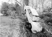  ?? MARK HUMPHREY/AP ?? A car that was carried by floodwater­s rests against a tree in a creek Sunday in Nashville, Tennessee.