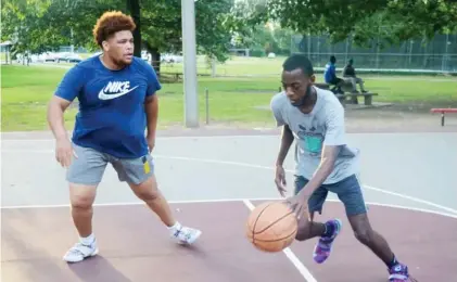  ??  ?? K.P. Peters, left, and Shammond Coleman of West Point play a game of one-on-one basketball at Mckee Park Wednesday evening. (Photo by Charlie Benton, SDN)