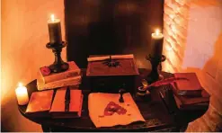  ??  ?? Candles and books are arranged on a table before a photo shoot of a room in Bran Castle.