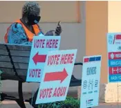  ?? SUN SENTINEL
JOE CAVARETTA/SOUTH FLORIDA ?? A poll worker waits for voters as polls open Tuesday at Spanish River Library in Boca Raton.