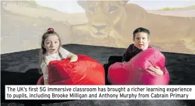  ??  ?? The UK’s first 5G immersive classroom has brought a richer learning experience to pupils, including Brooke Milligan and Anthony Murphy from Cabrain Primary