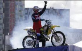  ?? ALASTAIR GRANT — THE ASSOCIATED PRESS FILE ?? In this file photo, Nitro Circus ringleader and stunt profession­al Travis Pastrana celebrates after he performed the first motorcycle backflip over the River Thames with a 75-foot wide gap between two floating barges, in London. Fifty years after Evel...