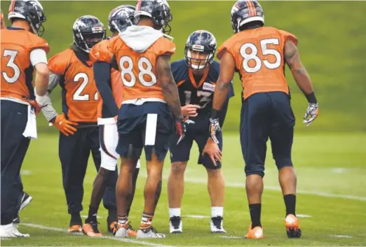  ?? Joe Amon, The Denver Post ?? Quarterbac­k Trevor Siemian, center, calls a play Tuesday, the Broncos’ first of 10 days of OTAs, at Dove Valley.